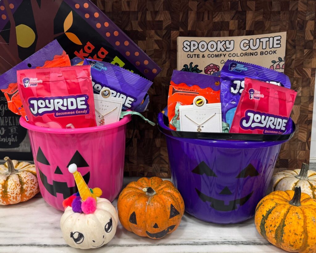 Two finished Halloween boo baskets filled with candy, books, small gifts, and seasonal treats