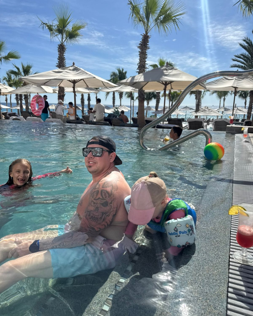 Dad and daughters swimming together in the pool at Garza Blanca Cabo
