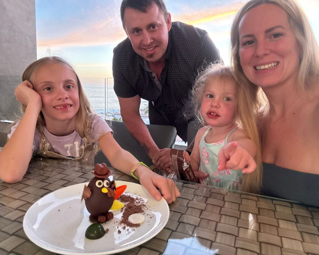 Family holding a Thanksgiving turkey-shaped dessert