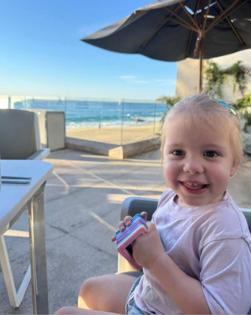 Young girl eating breakfast on a patio overlooking the ocean