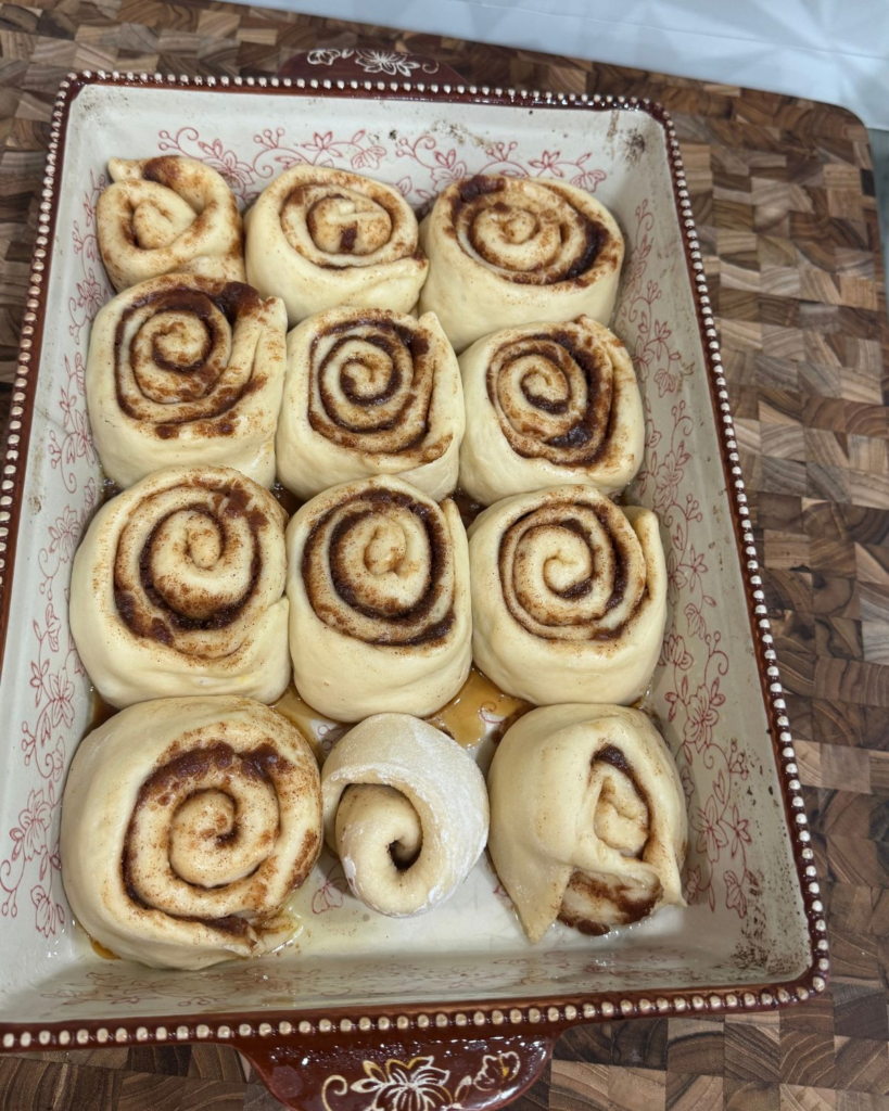 Homemade cinnamon rolls in a baking dish after their second rise