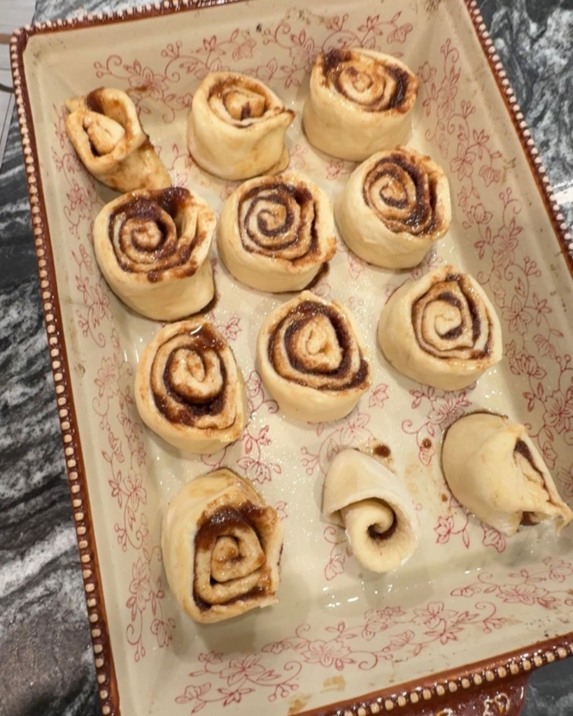 Cut cinnamon rolls arranged in a baking dish before the second rise