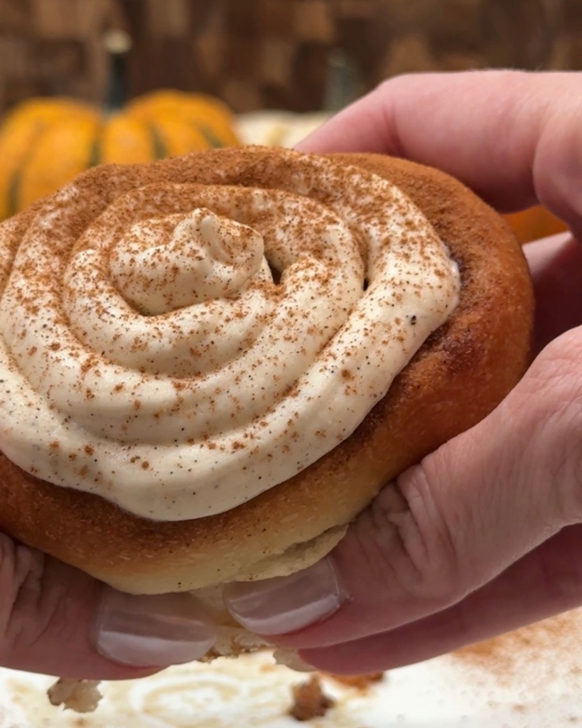 Homemade cinnamon roll topped with cream cheese frosting and cinnamon