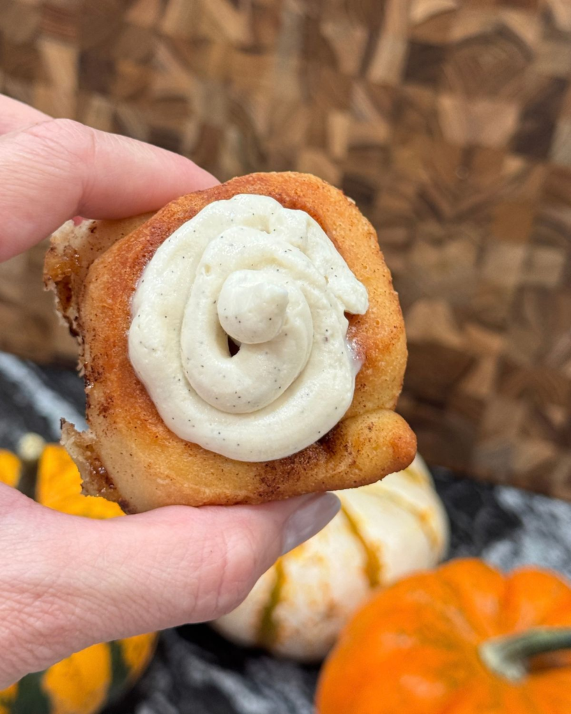 Whole homemade cinnamon roll topped with cream cheese frosting
