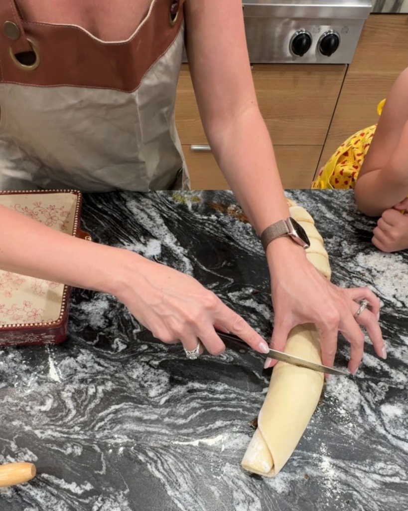 Cutting rolled cinnamon roll dough into individual pieces
