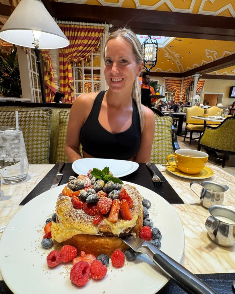 Julie seated at Terrace Pointe Café with a large berry-topped breakfast dish