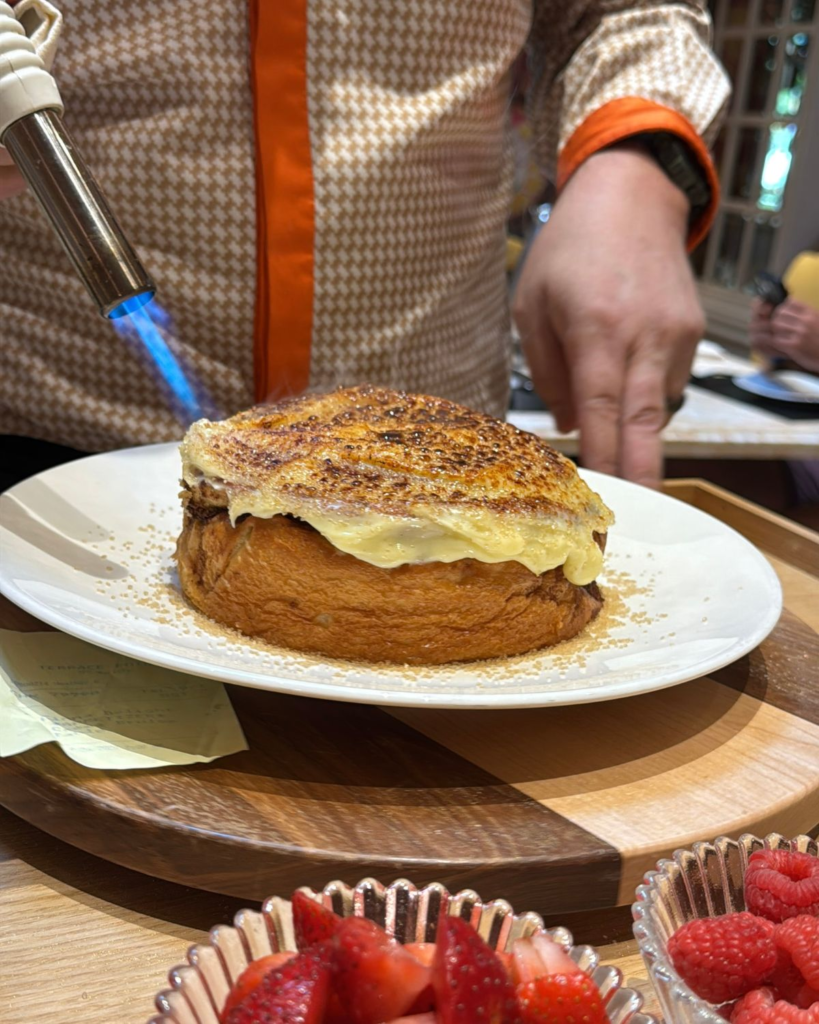 Server preparing a crème brûlée cinnamon roll tableside at Terrace Pointe Café