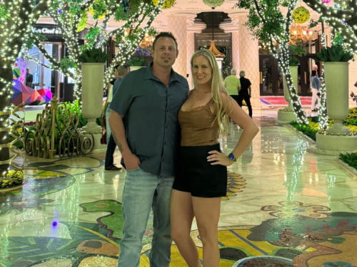 Julie and Corey standing together in a landscaped courtyard at Wynn Las Vegas
